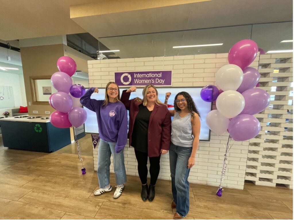 Photo de trois femmes posant pour la Journée internationale de la femme au siège de Planview à Austin, au Texas.