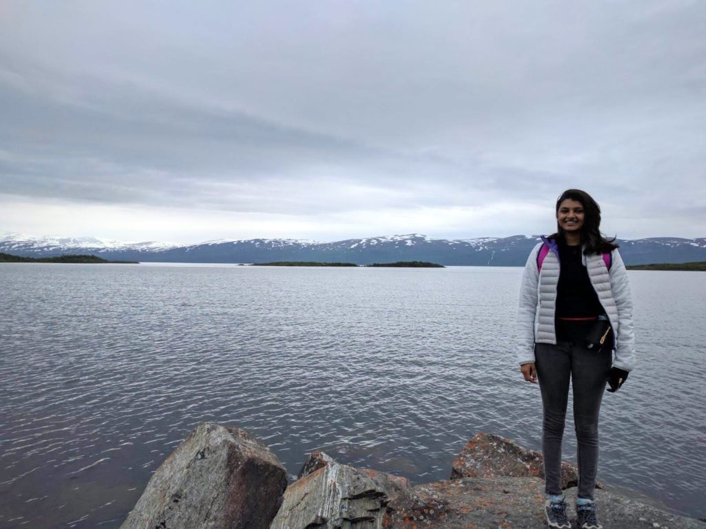 Bild på Sujatha Prabhakar som står framför en sjö. 